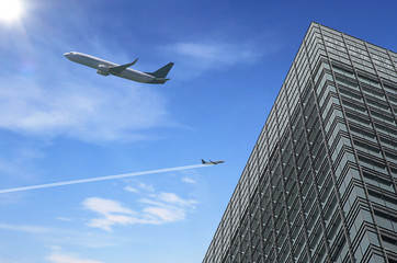 Obraz premium Airplane flying over building tower city and sunny