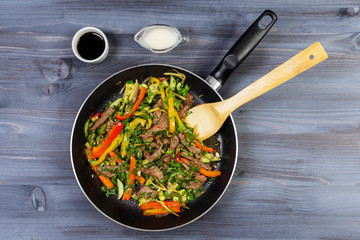 Ingredients for cooking and empty cutting board on an old wooden table. Food background with copyspace