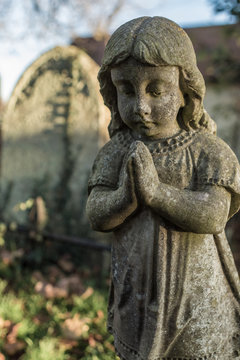 Statue of praying  child in graveyard