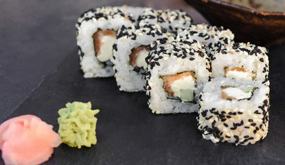 Japanese sushi roll philadelphia on black stone. Selective focus. 