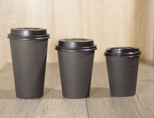 three paper Cup of black coffee on wooden background