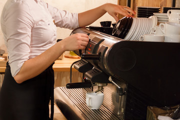Woman preparing coffee on coffeemaker