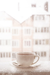 Cup of hot tea outdoor in snowing day.
