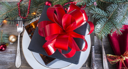 Gift box on table setting for christmas dinner