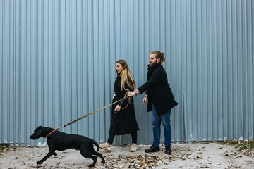 Cute young hipster couple having fun with their dog