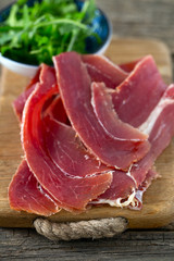 jamon and rucola on wooden surface