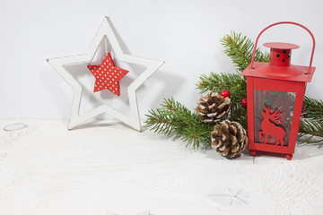 Christmas decoration with christmas star, christmas lantern and pine cones and pine branch on white wood background