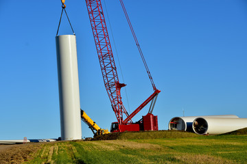 Fototapeta premium Installing base section of tower for wind turbine as part of wind farm generating clean power in ND.