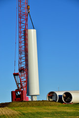 Installing base section of tower for wind turbine as part of wind farm generating clean power in ND.