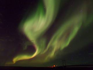 Breathtaking Green and Pink Color Northern Lights Dancing over the Bridge, Southern Part of Iceland 