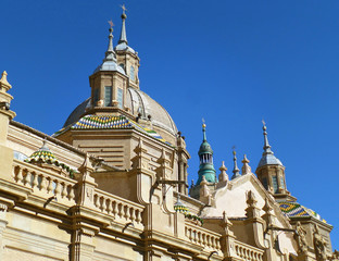 Fototapeta na wymiar Stunning Domes and Towers of Cathedral-Basilica of Our Lady of the Pillar under Vibrant Blue Sky, Zaragoza in Spain 