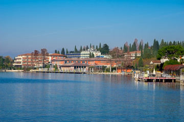 Landscape of Sirmione town with baths structure and buildings on Garda lake