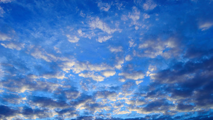 Fototapeta premium Chmury jasne i ciemne na niebieskim niebie.