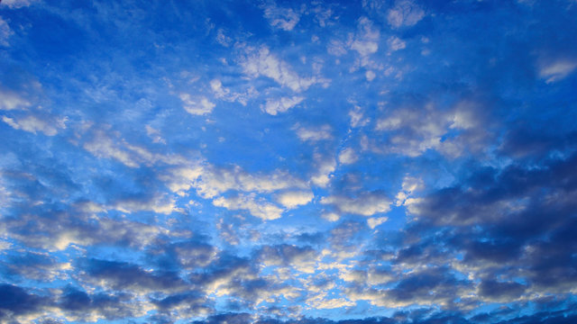 Fototapeta Chmury jasne i ciemne na niebieskim niebie.