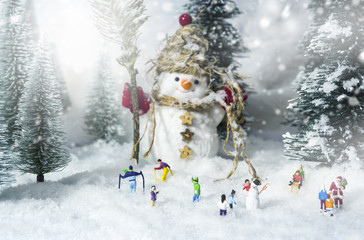 Snowman and people in pine woods during winter