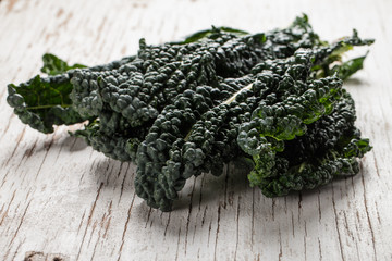 Horizontal shot of organic lacinato kale on white table