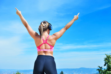 Success fitness winning woman concept with earphones.