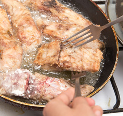 fish is fried in a pan