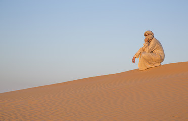 Fototapeta na wymiar man in traditional outfit in a desert near Dubai