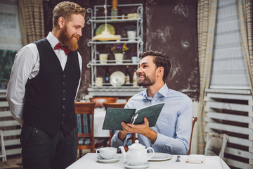 Smiling client making order in restaurant