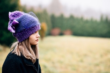 Thoughtful young woman in woolen violet blue cap