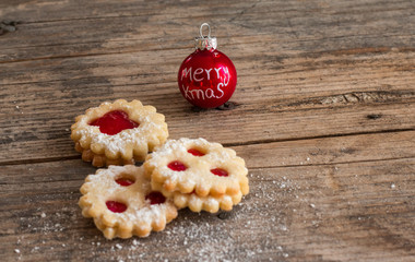 Weihnachtskekse und Weihnachtskugel auf rustikalem Holz