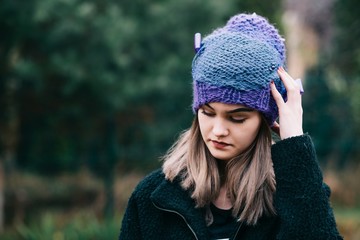 Thoughtful young woman in woolen violet blue cap