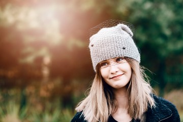 Happy smiling young woman in woolen grey cap