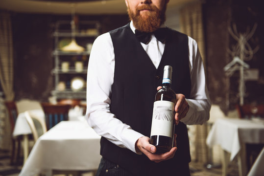 Man holding polished bottle with alcohol