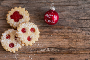 Weihnachtskekse und Weihnachtskugel auf rustikalem Holz, Breitbild
