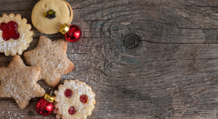 Weihnachtskekse und Weihnachtskugeln auf rustikalem Holz, Breitbild mit Textfreiraum