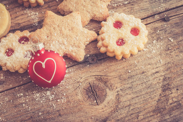 Weihnachtskekse und Weihnachtskugel auf rustikalem Holz