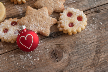 Weihnachtskekse und Weihnachtskugel auf rustikalem Holz