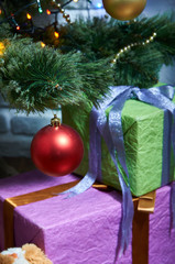 Luxury Christmas balls hanging on the Christmas tree. Christmas decorations closeup. Gifts for children are under the tree.