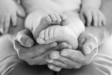 Father's hands holding feet of  his baby
