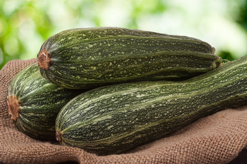 green zucchini or courgettes on sackcloth with a blurred background