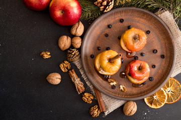 Baked apples on brown plate with holiday Christmas decoration