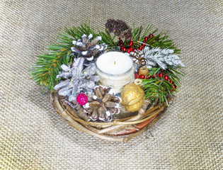 a wreath of fir branches with candles, cones and nuts