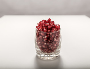 Fresh red pomegranate seeds sprinkled in a glass