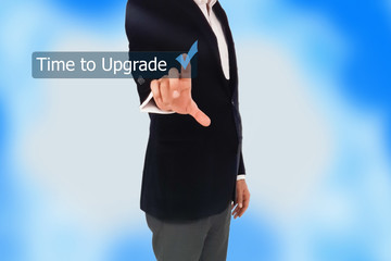 Businessman pressing time to upgrade word on virtual button 