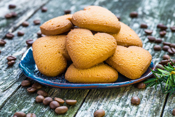 Plate with tasty Christmas cookies on wooden table