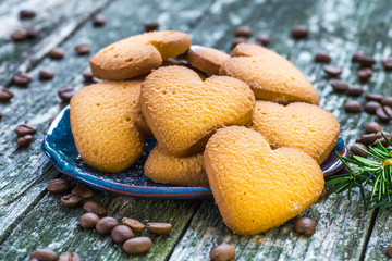 Plate with tasty Christmas cookies on wooden table