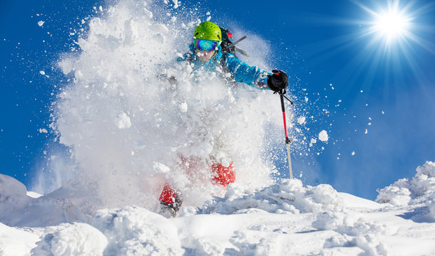 Freeride skier on piste running downhill