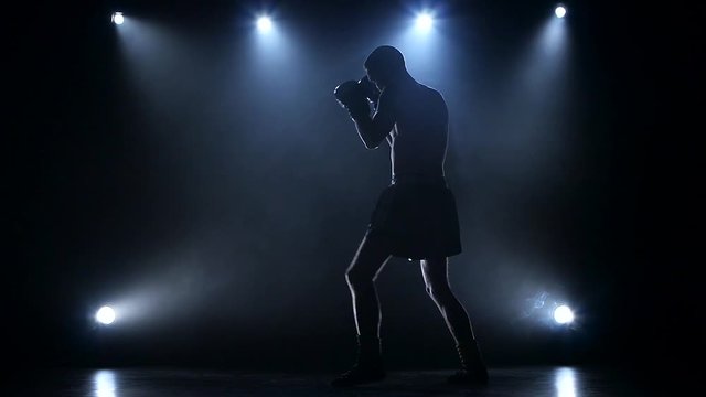 Training a blow boxer. Dark studio with spotlights
