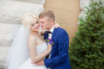 Fototapeta premium The groom gently hug the bride's shoulders
