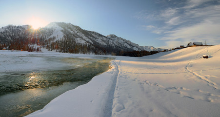 A small river in the Altai mountains, rural winter landscape.
