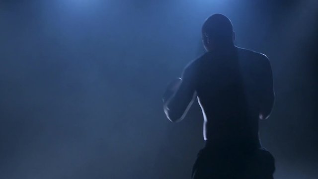 Training a boxer before a fight. Slow motion in the smoke