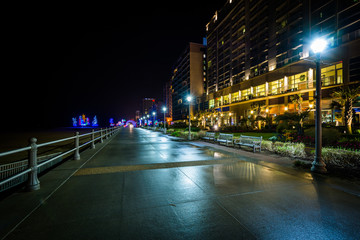 Fototapeta na wymiar The boardwalk and highrise hotels at night in Virginia Beach, Vi