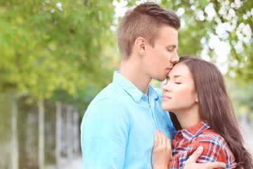 Portrait of beautiful young couple outdoors on blurred background
