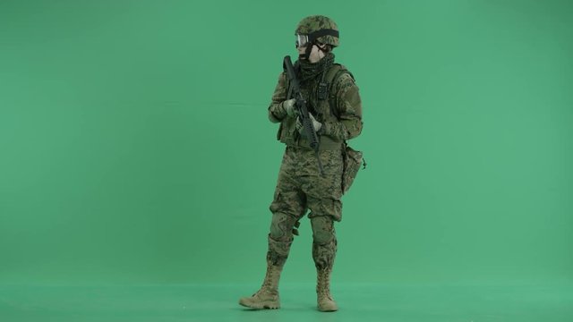 Soldier standing and looking around at green screen